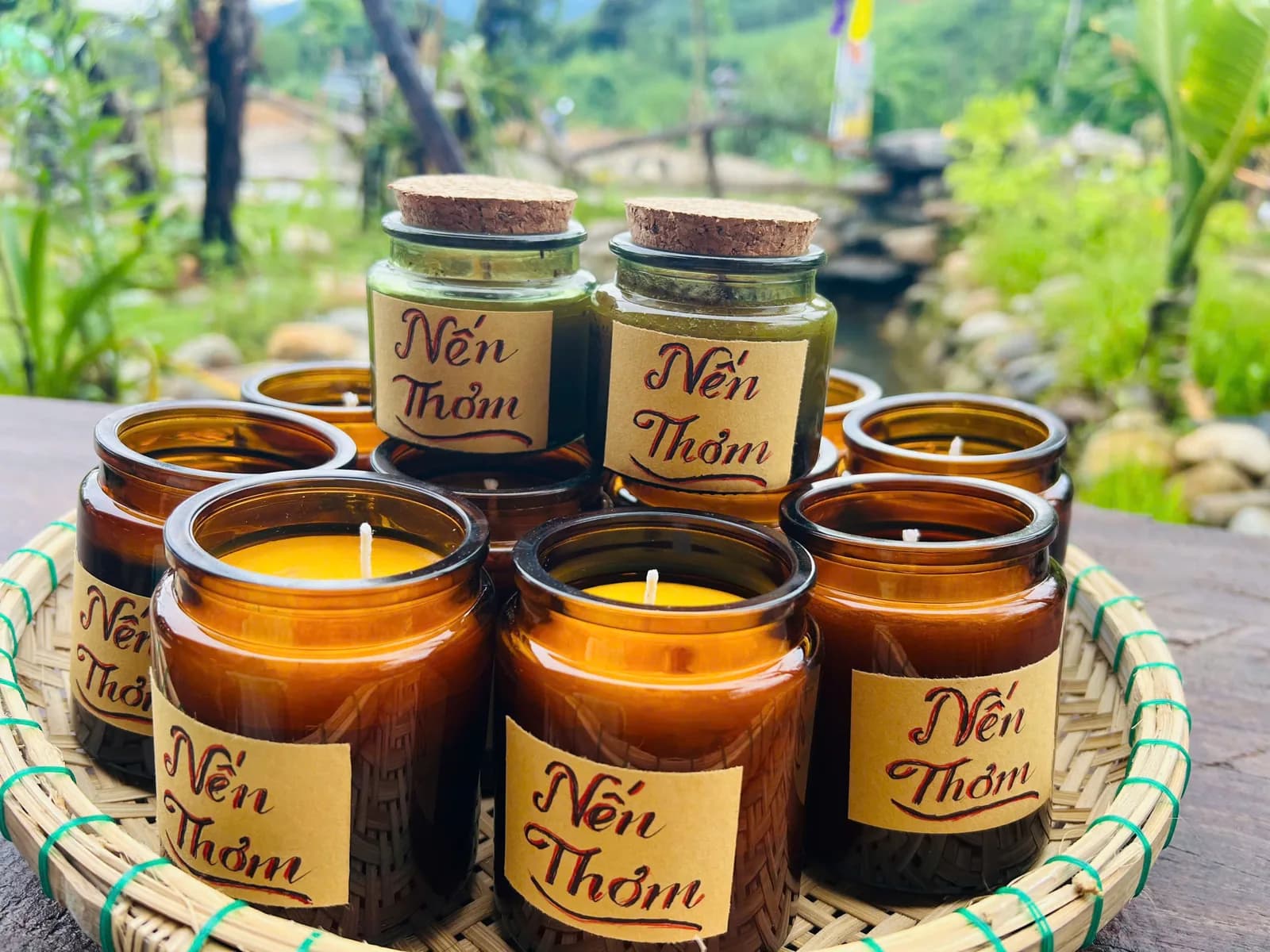 Nến thơm đựng trong lọ hổ phách, đặt trên khay đan